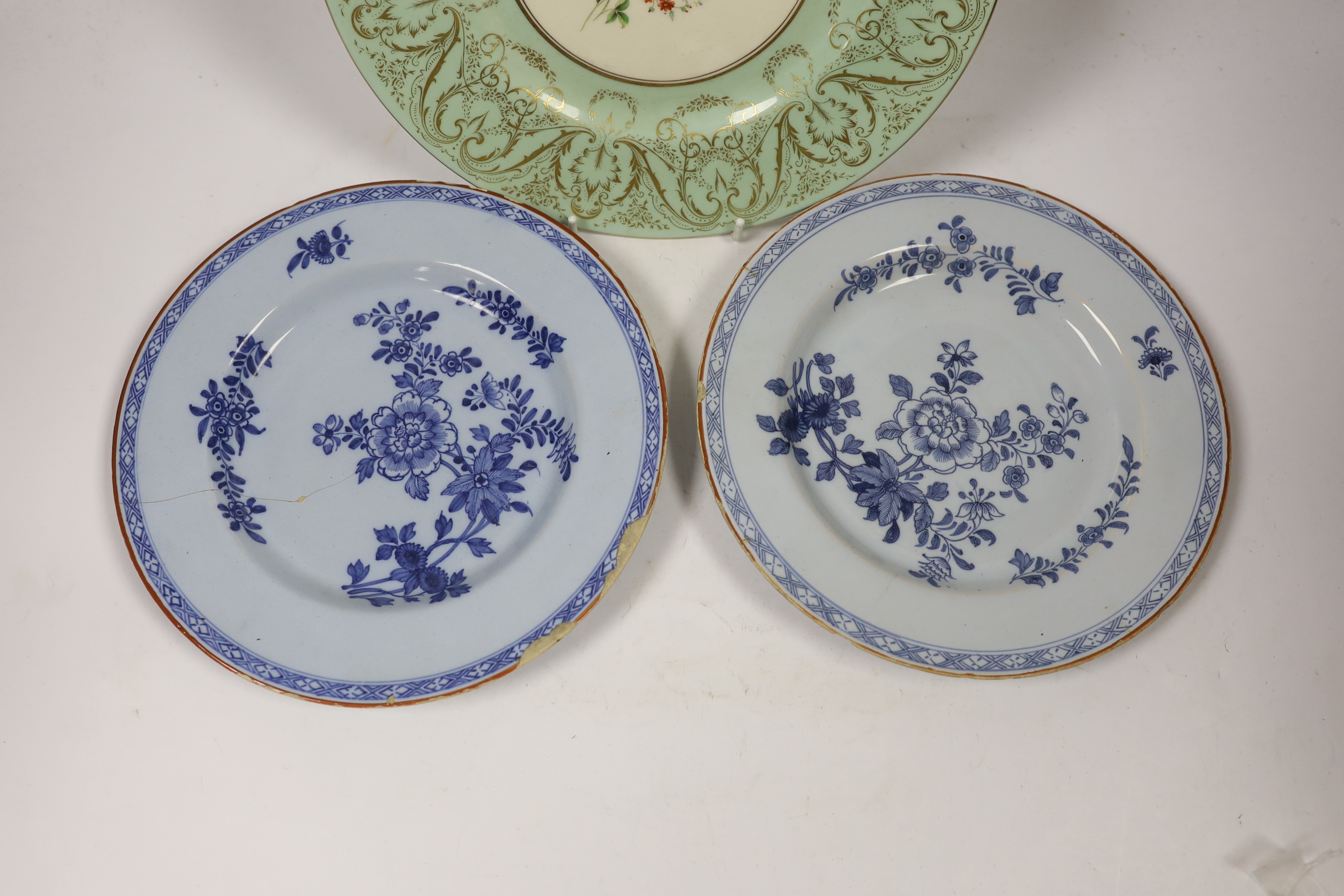 A pair of Delft plates, one dated 1771 and another Royal Worcester floral decorated plate, 27cm diameter